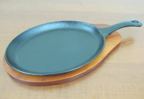 Oval sizzling platter with handle and wooden base