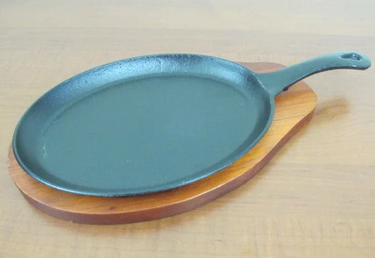 Oval sizzling platter with handle and wooden base